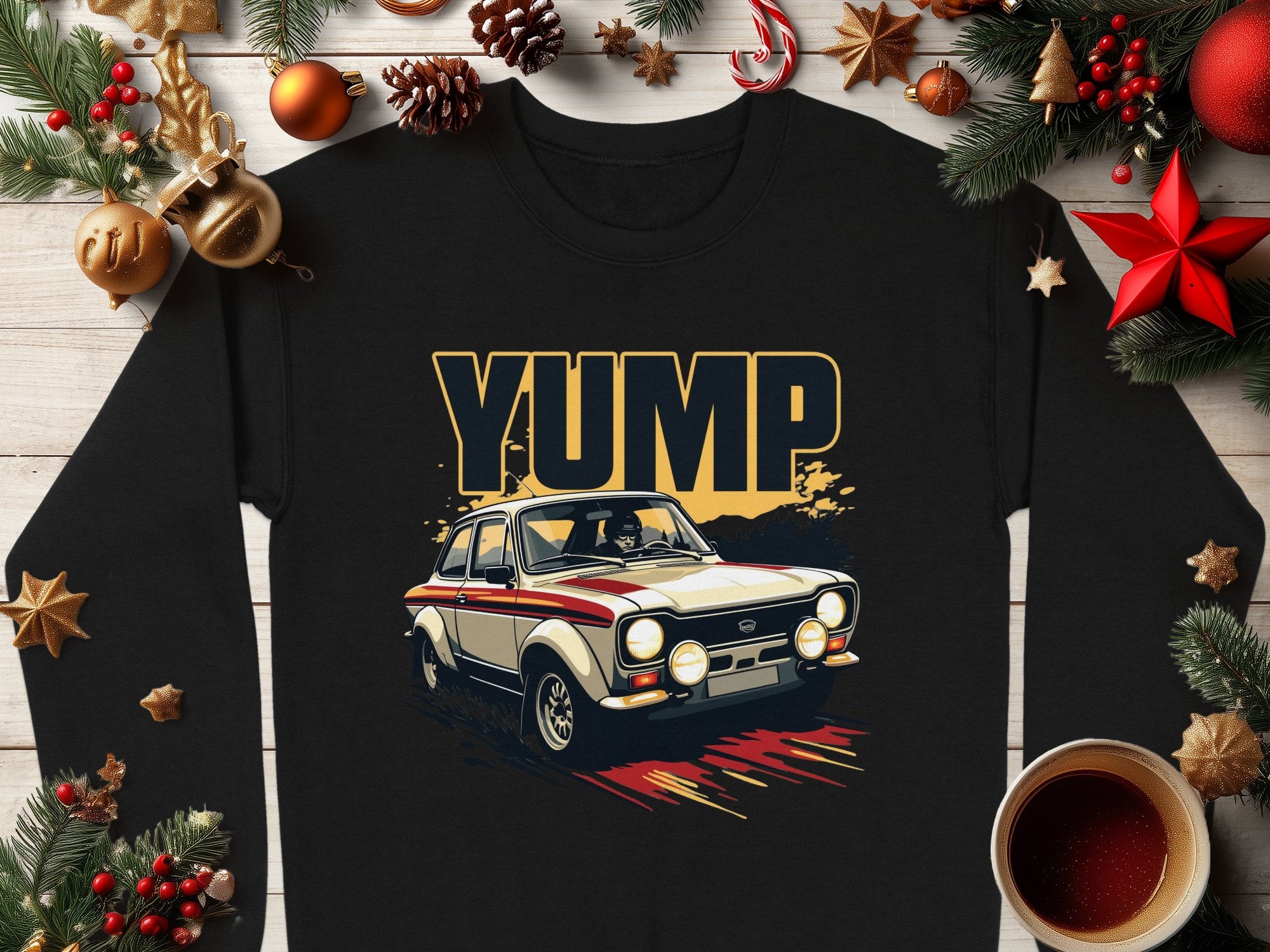 Garment Graphics black t-shirt features a vintage rally car with YUMP in bold letters, adorned with holiday decor including pine branches, pinecones, stars, ornaments, a candy cane, and a cozy coffee cup on wood.