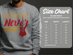 Someone wearing a lively gray Garment Graphics sweatshirt features a vivid red guitar and the phrase Music Never Sleeps, ideal for music lovers. The image includes a size chart for the Gildan 18000, with measurements in inches from S to 5XL.