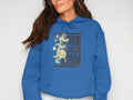 A person wears a Garment Graphics classic fit hoodie featuring a playful cartoon alligator holding a ball on a white background, with the See You Later Alligator design.