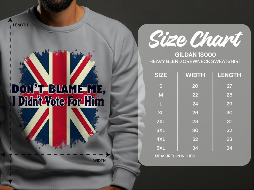Someone is wearing a cozy gray Garment Graphics sweatshirt with a bold British flag design and the phrase Dont Blame Me, I Didnt Vote For Him. Beside them is a size chart for the Gildan 18000 sweatshirt, listing sizes S to 5XL in inches.