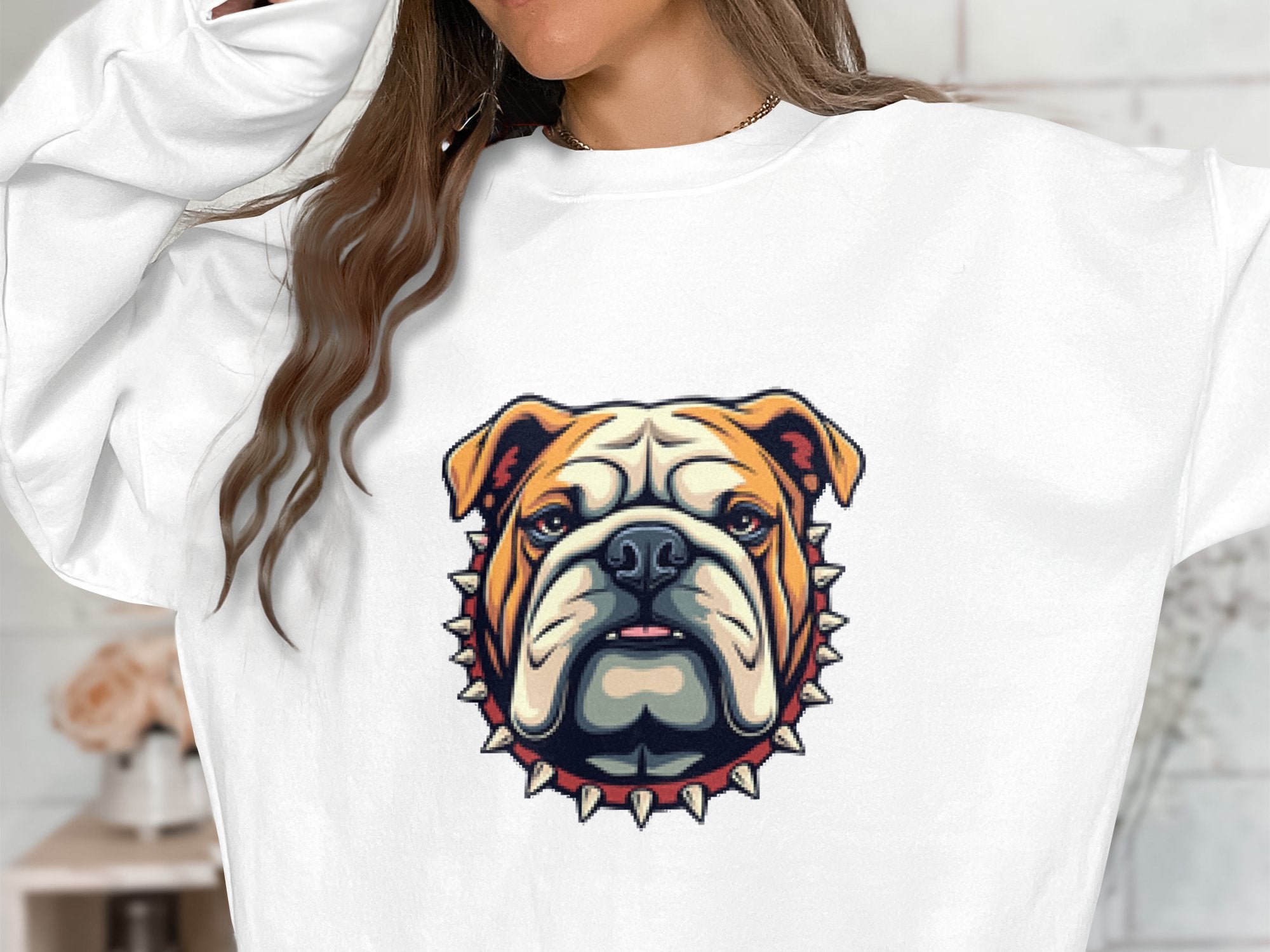 An individual wears a Garment Graphics white unisex sweatshirt, showcasing a bulldog graphic with a spiked collar. The fit is comfortable, their face is obscured, and the background appears artistically blurred.