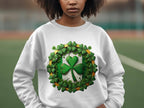A person wears a Garment Graphics white sweatshirt featuring a large green shamrock, embodying the Irish spirit, surrounded by smaller shamrocks in a circle. The blurred outdoor field enhances the charm of this Circle Design Sweatshirt.