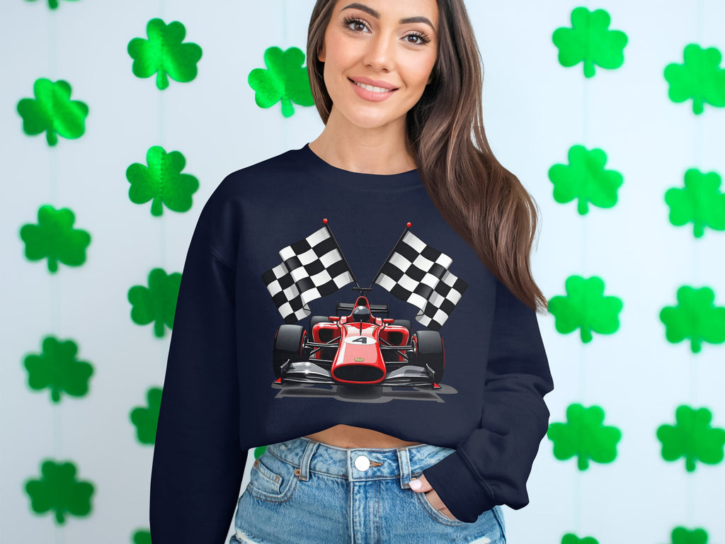 A person sports a vibrant Garment Graphics sweatshirt featuring a racing car and checkered flags, standing against a wall of green shamrocks, perfectly embodying motorsport enthusiasm.