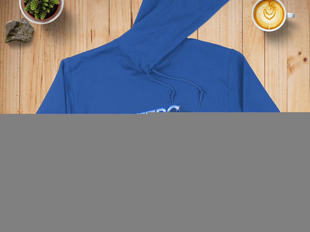 A blue Garment Graphics hoodie featuring the vibrant RETRO design is displayed on a wooden surface, accompanied by a denim jacket for a trendy modern look. Nearby are a latte with artistic foam, a potted plant, and a rock.