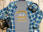 A gray Garment Graphics t-shirt featuring Father and Son Fishing Partners for Life with a fishing motif is styled with a cozy sweatshirt, black headphones, and a camera on a wooden background.