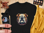 A bold black sweatshirt with a bulldog and spiked collar design from Garment Graphics sits on a wooden surface. Its surrounded by pink loafers, sunglasses, nail polish, makeup brushes, an eyeshadow palette, a yellow jacket, and a blue pouch. Available in unisex sizing for versatile wear.
