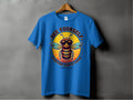 A blue T-shirt from Garment Graphics Summer Edition hangs on a gray wall, featuring a cool bee with sunglasses and a jacket. The text reads Bee Yourself above and Everyone Else Is Taken below. Available in family sizing, its perfect for spreading the buzz!.