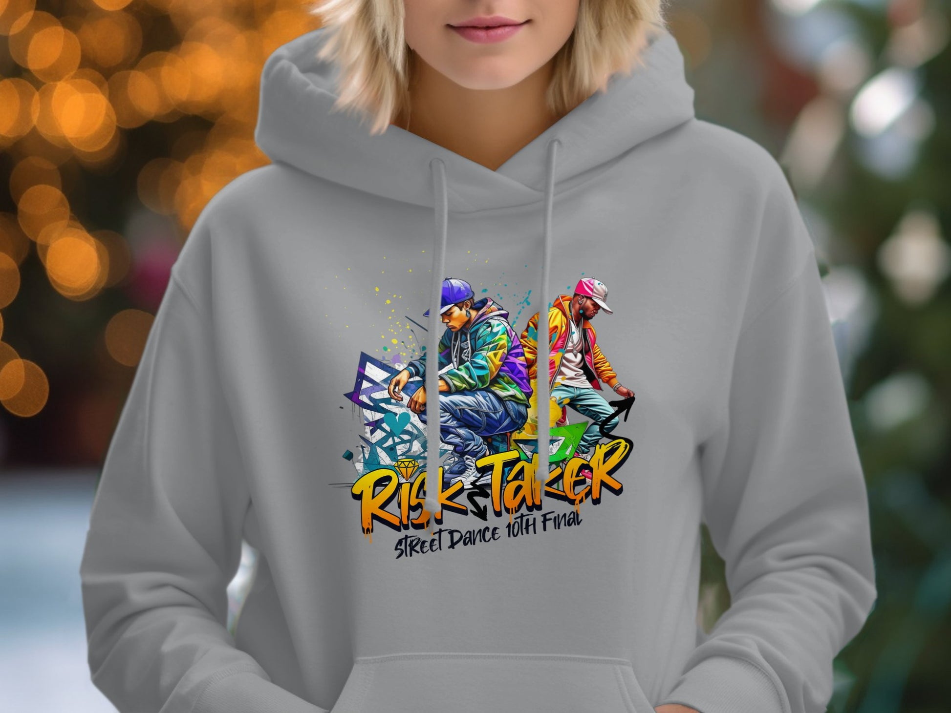 Wearing a Garment Graphics light gray hoodie adorned with dynamic street dancers and the text Risk Taker Street Dance 10th Final against warm golden bokeh, this piece is ideal for bold fashion lovers.