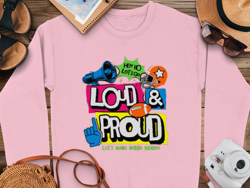 Garment Graphics pink sweatshirt features vibrant Loud & Proud text, graphics like a megaphone, blue foam finger, and football. Accompanied by a hat, sunglasses, notebook, and camera. Available in unisex sizing for all to enjoy Loud and Proud Sweatshirts.