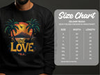 A person wears a black Garment Graphics One Love Sweatshirt, featuring a vibrant sunset between palm trees. The unisex design includes sizes from S to 5XL per the Gildan 18000 size chart, outlining width and length.