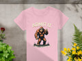 The Admit It Bigfoot pink t-shirt from Garment Graphics showcases a playful bigfoot giving a peace sign, with the text Admit it above and Life would be boring without me below. Its beautifully presented on a concrete backdrop surrounded by lush green leaves and colorful flowers.