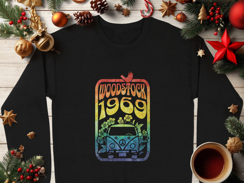 Garment Graphics offers a black shirt with retro vibes, featuring a colorful Woodstock 1969 design of a van, flowers, and peace symbol. This vintage piece is stylishly surrounded by Christmas décor like pinecones and ornaments on wood.