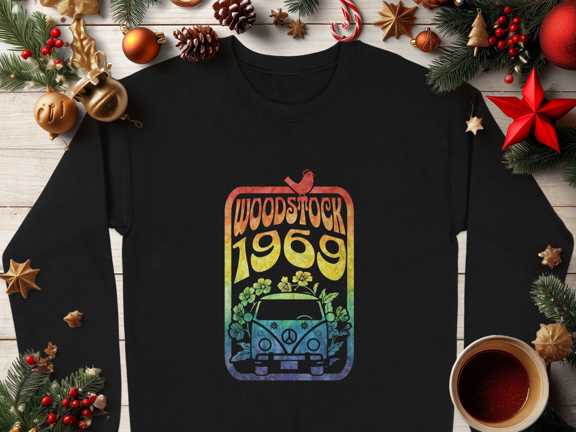 Garment Graphics offers a black shirt with retro vibes, featuring a colorful Woodstock 1969 design of a van, flowers, and peace symbol. This vintage piece is stylishly surrounded by Christmas décor like pinecones and ornaments on wood.