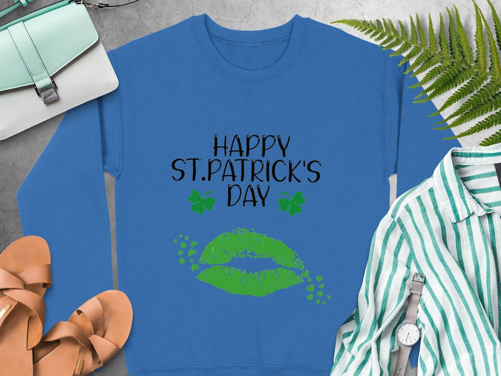 Garment Graphics St. Patricks Day blue sweatshirt features Happy St. Patrick’s Day in black and green, with a green lips clover kiss and shamrocks, ideal for a festive look when paired with sandals, a purse, a shirt, and ferns.