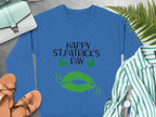 Garment Graphics St. Patricks Day blue sweatshirt features Happy St. Patrick’s Day in black and green, with a green lips clover kiss and shamrocks, ideal for a festive look when paired with sandals, a purse, a shirt, and ferns.