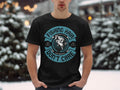 In a snowy scene, someone wears a Garment Graphics black graphic tee, showcasing a fish illustration with the fun text Fishing Hair Dont Care.