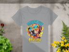 Garment Graphics offers a womens gray T-shirt featuring a dog with sunglasses and the text PAWSITIVE STYLISH above and CHILLIN LIKE A CANINE VILLAIN below. The design is complemented by green and yellow plants over a concrete background, creating a lively, fun look.
