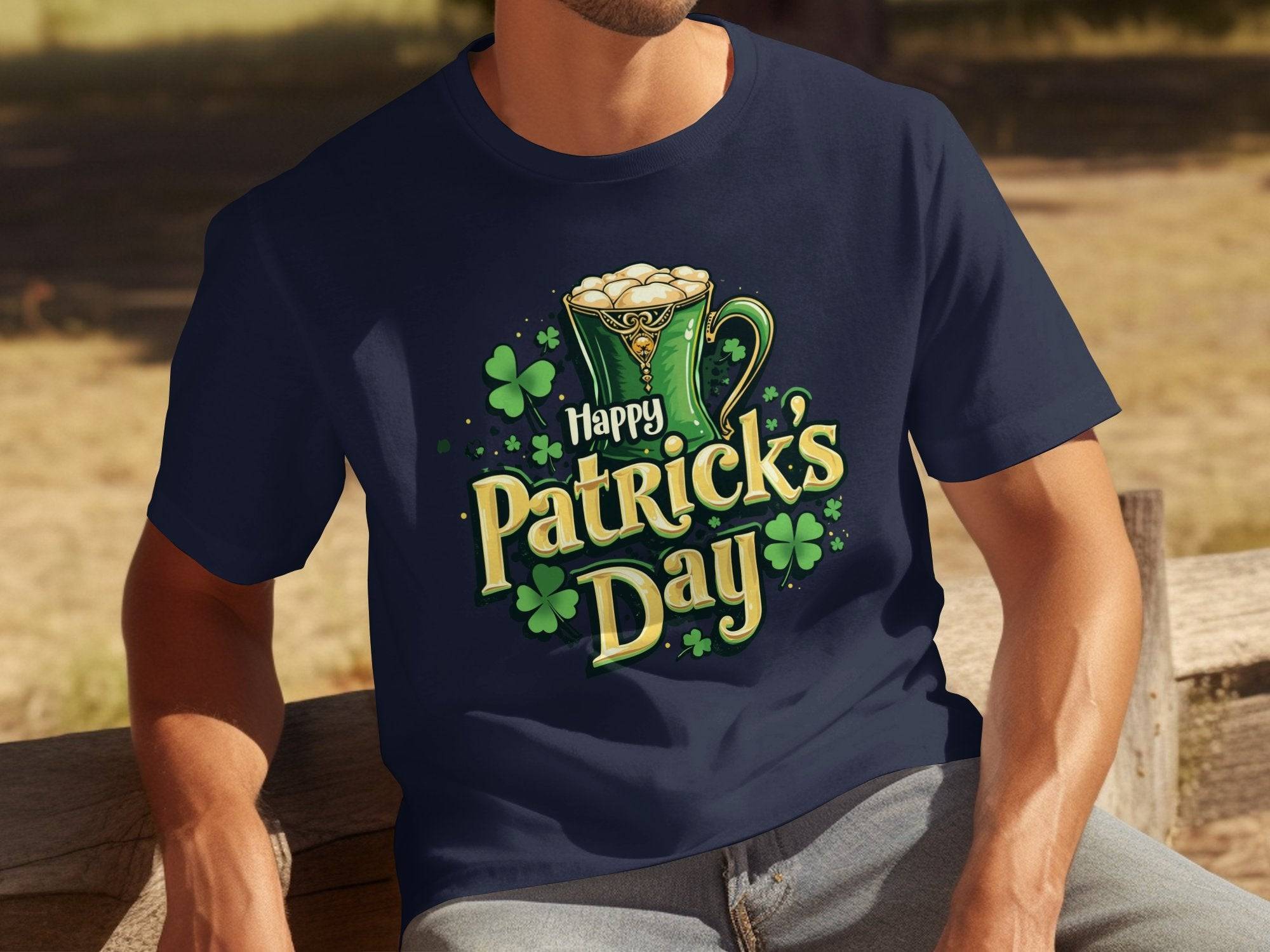 A person sports a Garment Graphics dark blue T-shirt featuring a Happy Patricks Day design with shamrocks and a beer mug as they enjoy the festivities on an outdoor wooden bench.