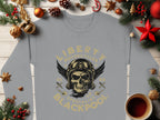 Garment Graphics offers a gray sweatshirt with Liberty Motorcycles Specialist Blackpool design, featuring a skull with goggles and wings. The backdrop includes pine branches, red stars, and a steaming cup on wood, merging unique style with Blackpool 2023 flair.