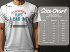 A man in a Garment Graphics white T-shirt featuring Id rather have a bad day than a good day stands before a Gildan 5000 Heavy Cotton size chart. This fishing tee is an ideal gift for anglers, available in sizes S to 5XL with measurements in inches.