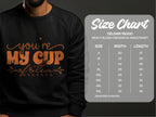 A cozy Garment Graphics sweatshirt ideal for tea lovers has Youre My Cup of Tea in vibrant orange. It comes with a detailed size chart for the Gildan 18000, listing sizes from S to 5XL with precise width and length measurements in inches.