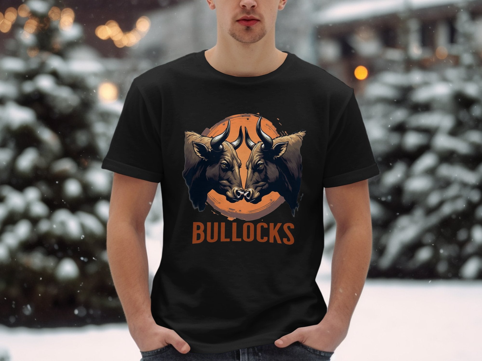 A person wears a Garment Graphics black classic fit T-shirt with two bulls, a basketball background, and BULLOCKS in orange. The Bullocks Pintable T-Shirt offers family sizing, perfect for snowy forest outings.
