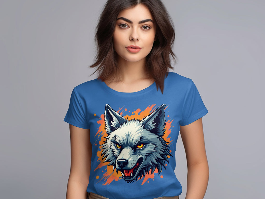 A woman with brown hair wears a bold wolf print T-shirt from Garment Graphics. The 100% cotton shirt features a wolfs head with an open mouth, surrounded by orange splashes on a plain gray background, creating a vibrant design.