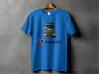 A blue t-shirt from Garment Graphics on a hanger showcases a Scania truck graphic, ideal for truck fans. The t-shirt features the Scania logo and name below the image, set against a plain gray wall.