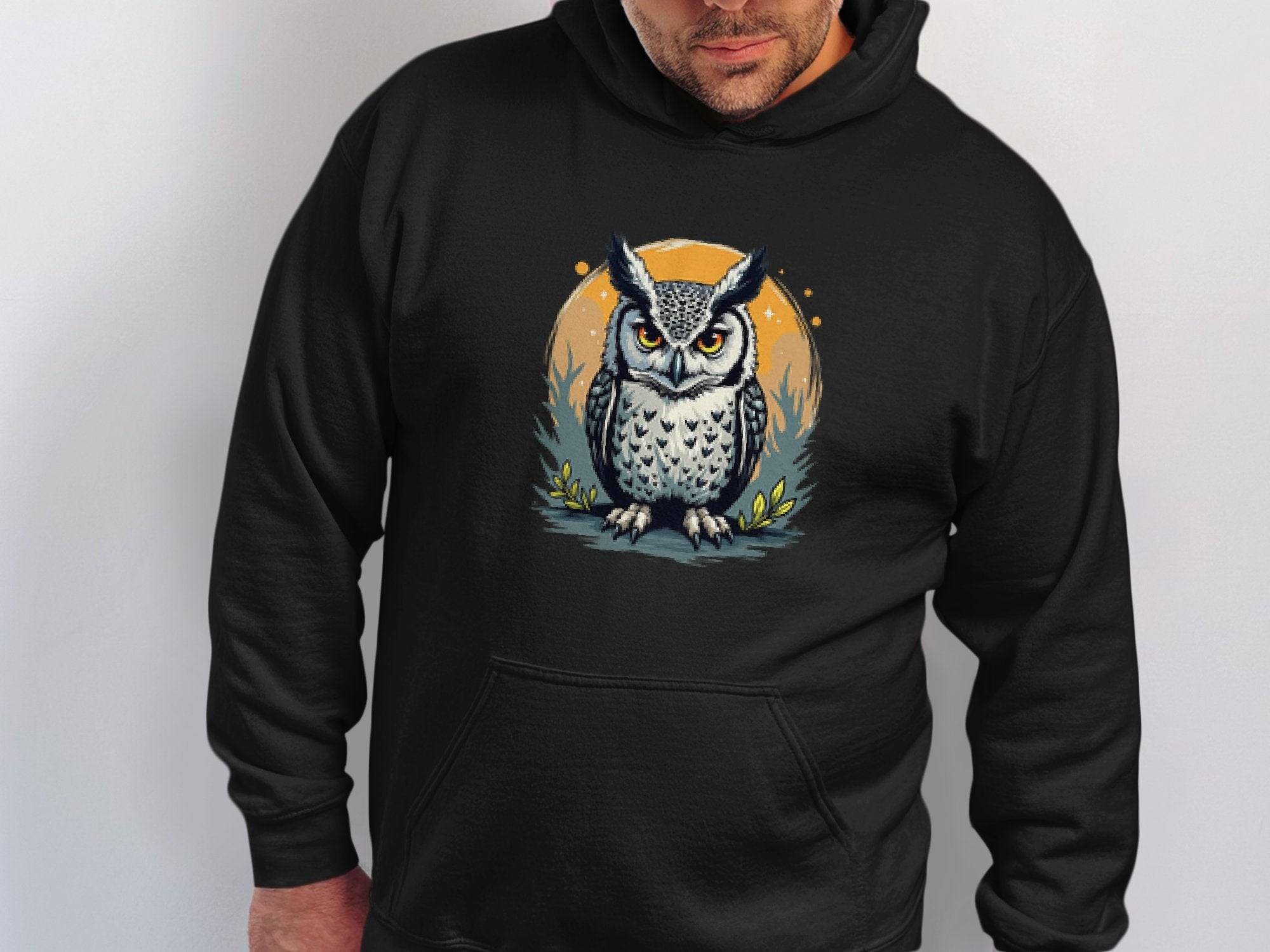 Dressed in Garment Graphics’ classic fit hoodie, adorned with owl artwork set against an orange leafy circle, the person looks down, enhancing the medium-heavy fabrics mystery by a plain white wall.