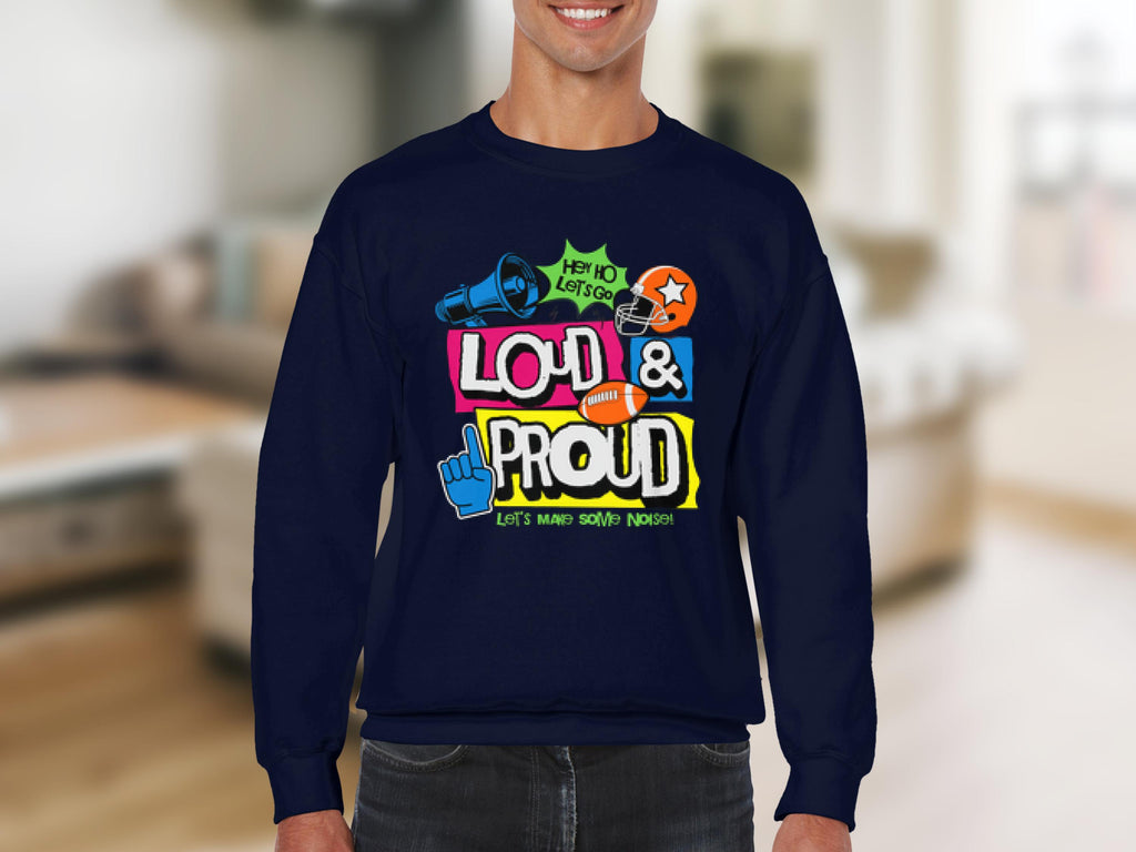 Someone wearing a Garment Graphics dark blue unisex sweatshirt with vibrant designs and the text LOUD & PROUD, featuring a megaphone, symbols, and phrases like Hey Yo Lets Go and Lets Make Some Noise! stands out uniquely against a blurred indoor background.