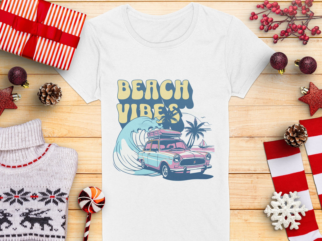 Garment Graphics presents a retro t-shirt showcasing a surf design with a vintage car, surfboard, and palm tree. The Beach Vibes text adds charm to the wooden backdrop adorned with holiday decorations like wrapped gifts, pine cones, and candy canes.
