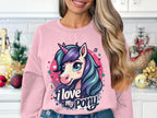 In a kitchen decorated for the holidays, someone with long, wavy hair wears a pink Garment Graphics sweatshirt featuring a colorful ponyunicorn design. Emblazoned with I love my pony, it adds charm to the festive scene.
