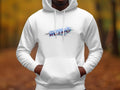 A person wears a white Retro 3D Graphic Hoodie from Garment Graphics, hands in the front pocket. RATIO is displayed in vivid colors across the chest, set against a blurred backdrop of autumn leaves.