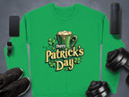 A vibrant Garment Graphics green sweatshirt features a festive Happy Patricks Day graphic with a beer mug and shamrocks, surrounded by items like a smartphone, smartwatch, fitness tracker, dumbbells, sneakers, and portable speaker.