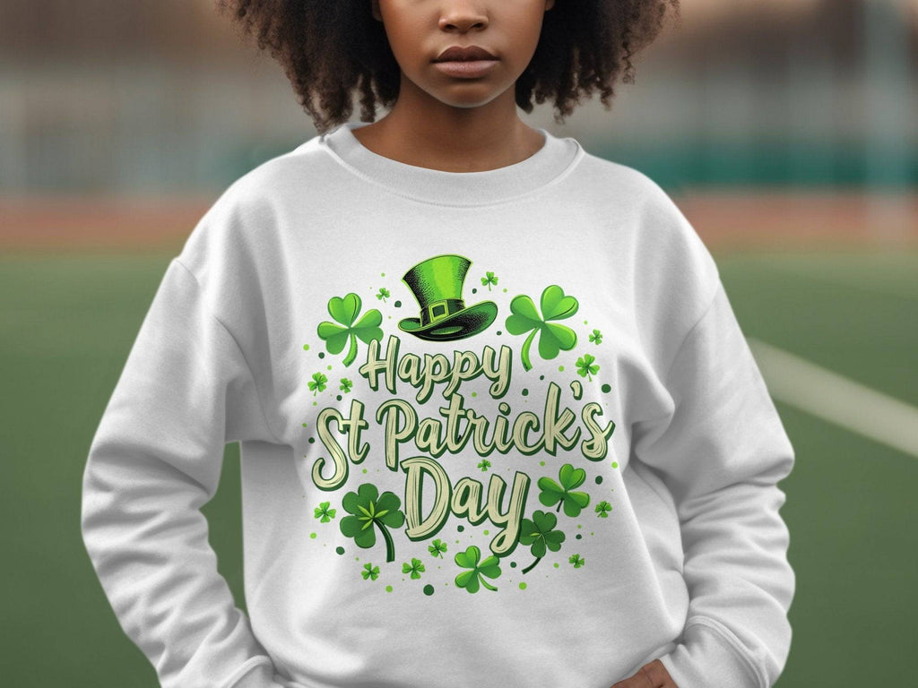 A person in Garment Graphics white sweatshirt, showcasing a St. Patricks Day design with a green hat, shamrocks, and Happy St Patricks Day text, radiates festive cheer against a blurred outdoor backdrop.
