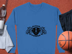 A blue sweatshirt from Garment Graphics features a black Scania Power 8 logo with stylized griffins. Its showcased on an orange background with a basketball, black shorts, water bottle, and white towel.