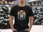 A man dressed in a Garment Graphics black T-shirt featuring an owl graphic stands amidst a snowy landscape, exuding artistic flair in the serene setting.
