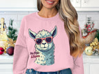 A woman in a kitchen wears Garment Graphics No Prob-Llama sweatshirt, showcasing a cartoon llama with sunglasses. Ideal for unisex sizes, the funny sweatshirt highlights her long, wavy hair against a white-tiled backsplash and festive holiday decor.
