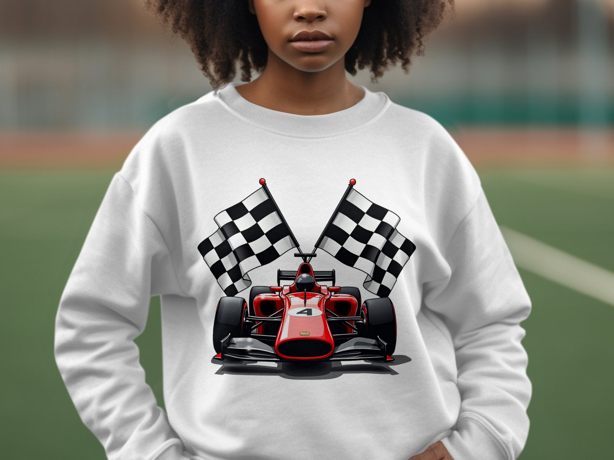 Against a blurred outdoor green surface, a person wears a vibrant Garment Graphics sweatshirt featuring a red racing car and black and white checkered flags. Ideal for motorsport enthusiasts, the persons face is partially visible.