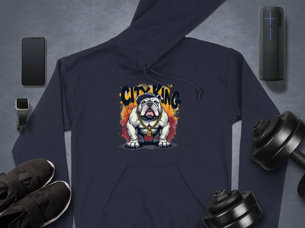 Garment Graphics navy blue hoodie with Graphic Bulldog Design and CITY KING text at the center is ideal for casual wardrobes, showcased with a smartphone, portable speaker, smartwatch, shoes, and dumbbells on a gray background.