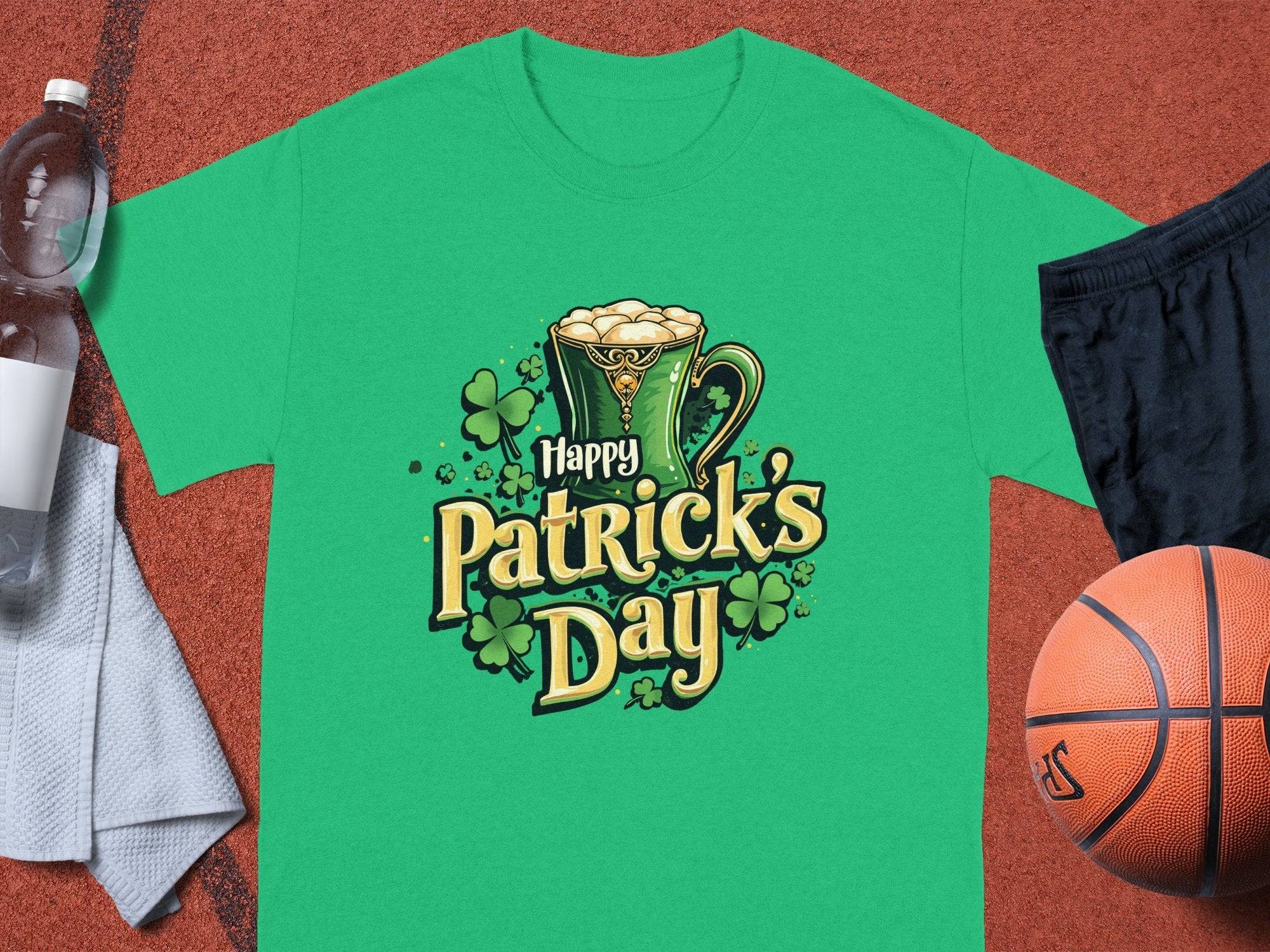 Garment Graphics Happy Patricks Day T-shirt with shamrock graphics stands out on an orange sports court. Pair it with a water bottle, white towel, black shorts, and a basketball for a festive and active day.