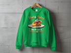 A green sweatshirt from Garment Graphics Hot and Spicy Sweatshirts collection hangs on a wooden hanger against a concrete wall. It features a playful pie character with whipped cream and the text, Hot & Spicy. You Wanna Piece of Me? in unisex sizes for all pie lovers.
