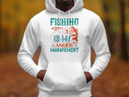 A person is wearing a Garment Graphics white hoodie from the Anglers Wardrobe collection, featuring a vibrant graphic with Fishing is my anger management and a fish caught by a rod, standing amid blurred autumn foliage.