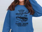 A person is wearing a blue Garment Graphics sweatshirt with automotive flair, showcasing a vintage car design and bold text: Classic London City Vintage Car Club and Classic Garage Old School Automotive.