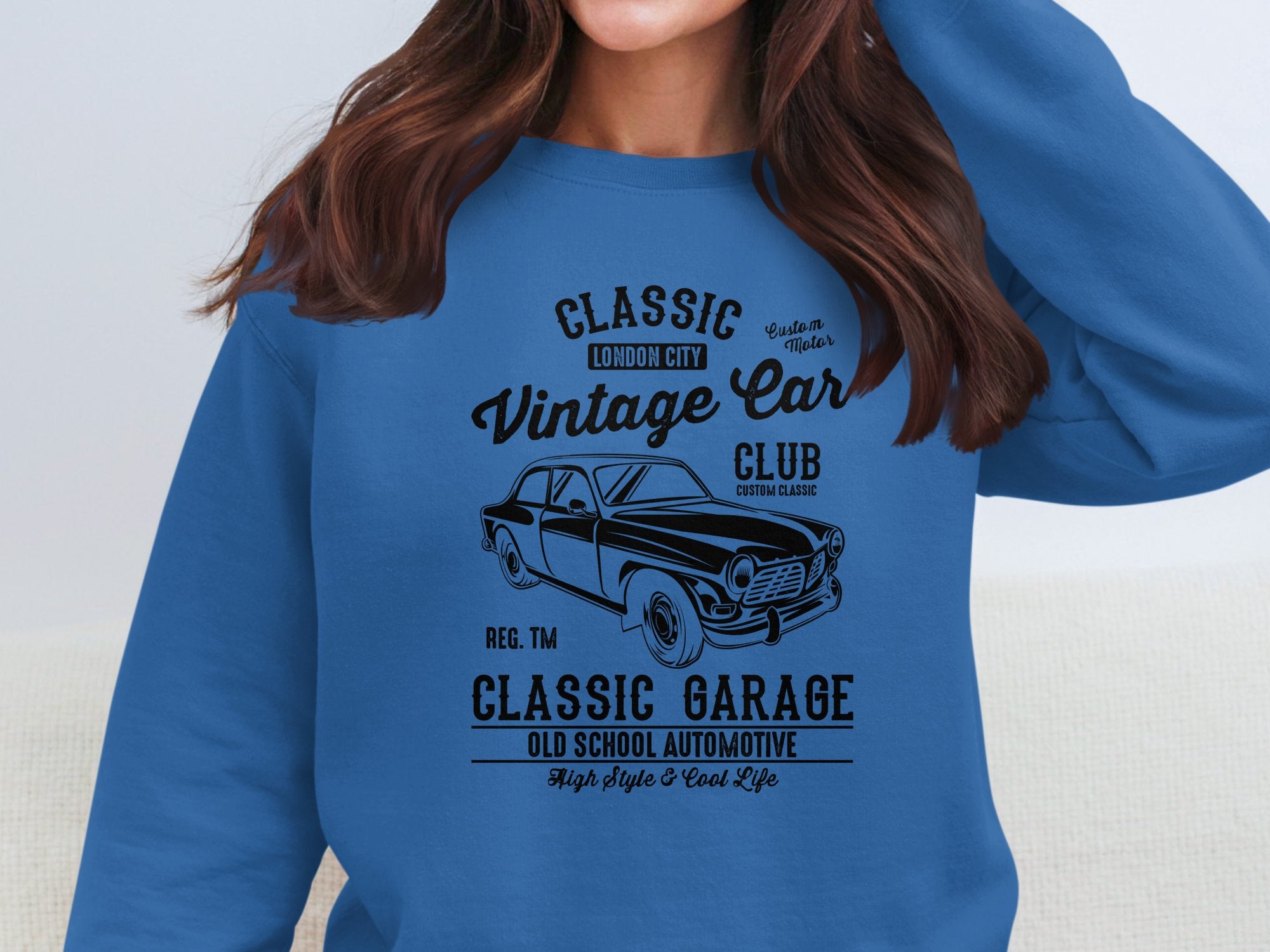 A person is wearing a blue Garment Graphics sweatshirt with automotive flair, showcasing a vintage car design and bold text: Classic London City Vintage Car Club and Classic Garage Old School Automotive.