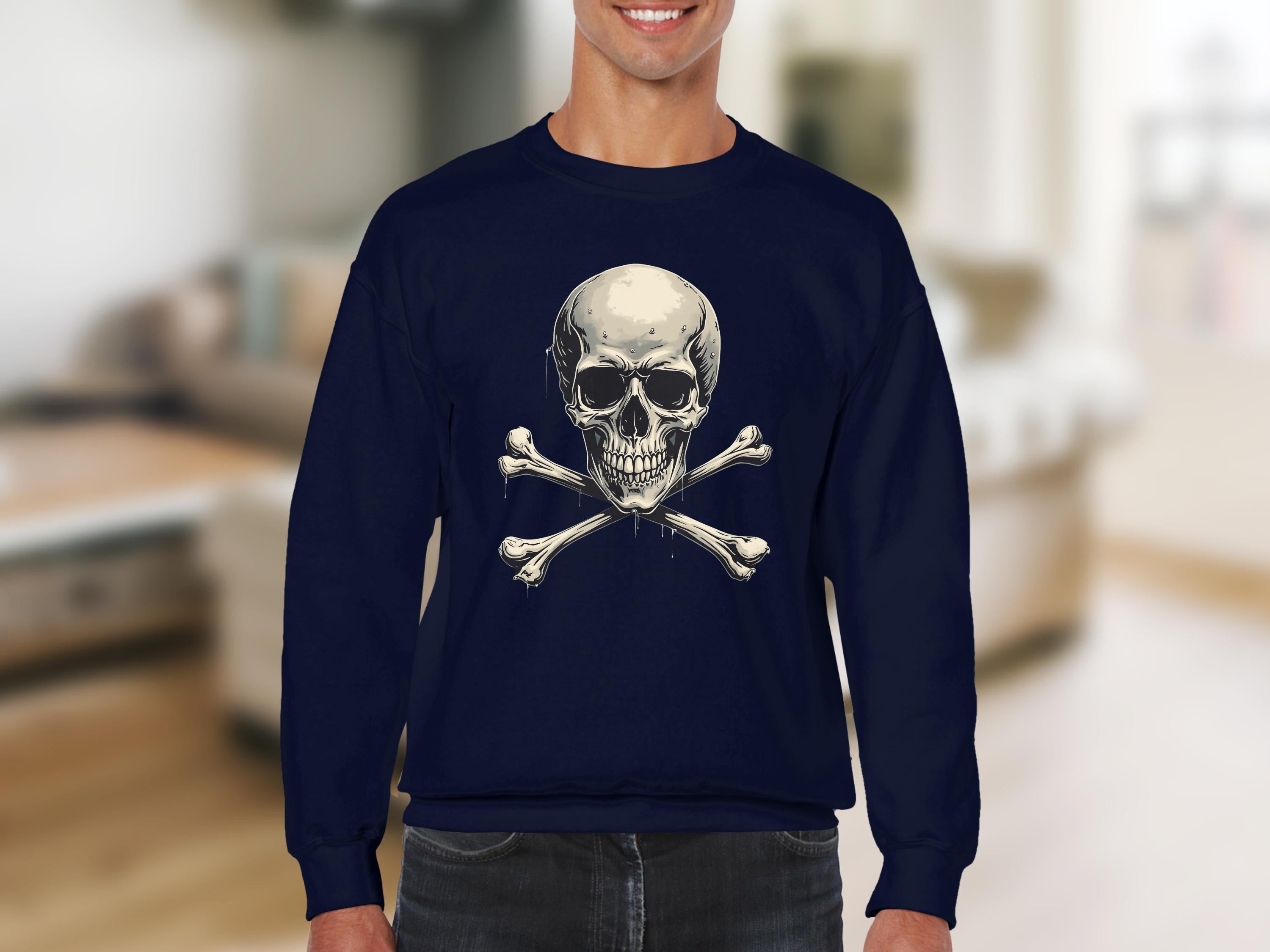 Decked out in an edgy style, someone wears a dark blue Garment Graphics sweatshirt with a skull and crossbones design. The softly blurred backdrop, hinting at an indoor setting with neutral tones, enhances the unisex allure of this striking fashion statement.