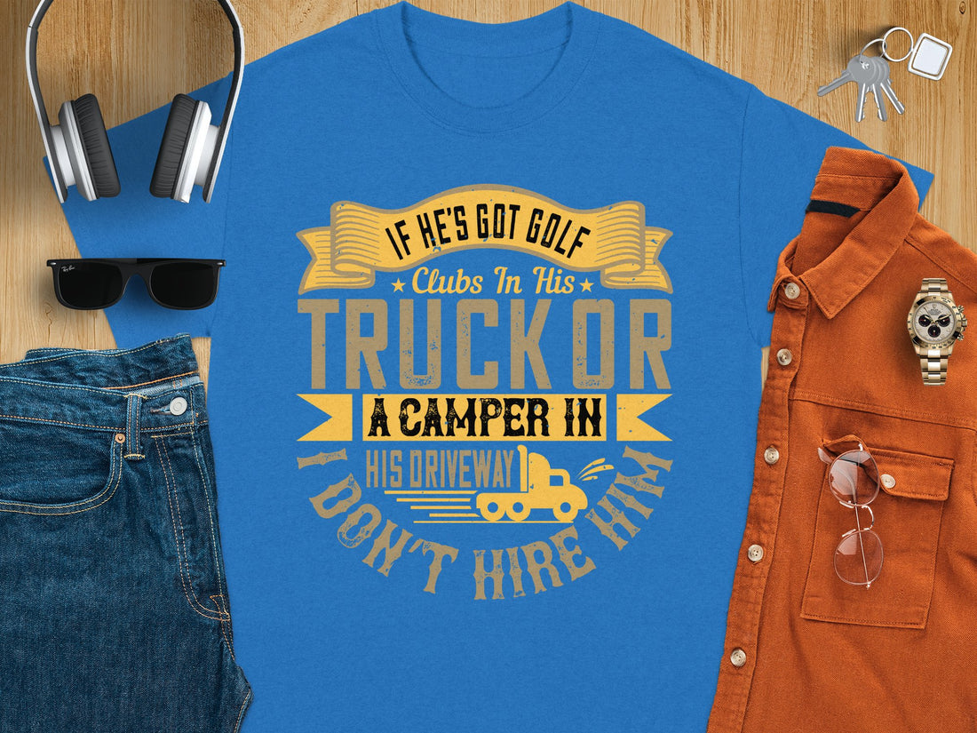 Wearing a Garment Graphics T-shirt, someone shows off a humorous quote in yellow and black: If hes got golf clubs in his truck or a camper in his driveway, I dont hire him. With a grassy backdrop, its the perfect gift for those who love humor on the green.