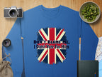 A blue unisex sweatshirt from Garment Graphics features a Union Jack and the text Dont Blame Me, I Didnt Vote For Him. Its presented on a wooden surface surrounded by a camera, lenses, chopped kiwi, a map, and a small drawstring bag.