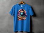 A Garment Graphics blue graphic T-shirt features a bold illustration of a hat-wearing gorilla with sunglasses and a chain, hanging on a wooden hanger. The vibrant text GORILLA GANGSTER is displayed beneath the image.