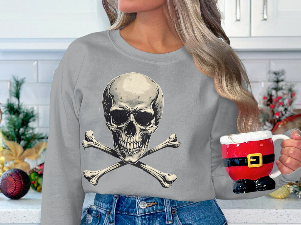 In a white kitchen adorned with Christmas ornaments and greenery, a person wearing Garment Graphics edgy gray skull-and-crossbones sweater cradles a Santa torso-shaped mug, forming a festive yet stylishly bold scene.